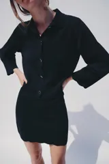 Chaqueta de punto color azul marino, con cuello solapa, manga larga y cierre frontal con botones metálicos. Presenta terminaciones en ondas en el bajo y los puños.