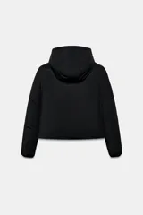 Anorak de corte corto y diseño minimalista, color negro. Cuenta con capucha integrada, cierre frontal con cremallera termosellada, bolsillos laterales con cierre y puños interiores elásticos. Posee acolchado interior y propiedades resistentes al agua y al viento.