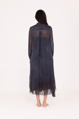 Vestido camisero largo midi de calce recto, confeccionado en tejido liviano y semitransparente, color verde oliva desgastado. Presenta cierre frontal con botones, cuello mao, mangas largas con puño y terminaciones irregulares y deshilachadas en el bajo.