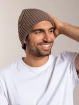 Gorro de lana marrón con diseño de punto canalé y etiqueta de cuero con logo en el lateral.