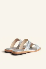 Sandalia plana de cuero color marrón, con tiras anchas y costuras blancas a la vista. Tiene punta cuadrada y un pequeño taco de 2 cm.