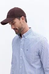 Camisa de manga larga Brooksfield de corte regular, confeccionada en tejido oxford de algodón con estampado de rayas verticales finas en color azul sobre fondo blanco. Presenta cuello abotonado, bolsillo frontal con logo de ave bordado y puños con botones.
