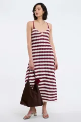 Vestido midi de tejido de punto con diseño de rayas horizontales en color bordó y blanco. Presenta escote en V, breteles finos ajustables y una silueta fluida y cómoda.