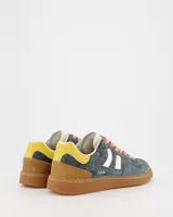 Championes urbanos Coolway modelo Goal, color azul con detalles en amarillo y marrón. Confeccionados en serraje suave con detalles en contraste de color, lengüeta preformada de piel con acolchado figurado, forro interior en piel, cordones planos de algodón bicolor intercambiables, cuello ligeramente acolchado y puntera reforzada con pespuntes decorativos. Suela flexible de goma y caucho. Nombre del modelo “GOAL” en tono oro envejecido en el lateral.