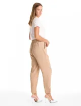 Pantalon de corte relajado color beige, con cintura plana en el frente y elástica en la parte posterior. Presenta pierna de corte recto, bolsillos laterales diagonales y bolsillos traseros simulados.