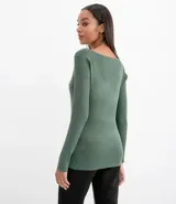 Suéter de punto color rosado, con cuello barco, mangas largas y puños con botones decorativos. El dobladillo también es acanalado.