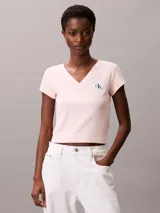 Remera de Calvin Klein confeccionada en algodón elástico con textura de canalé fino. Presenta un diseño de corte slim, cuello en V, manga corta y una insignia con el logo de la marca en el pecho.