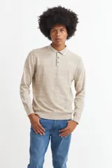 Sweater de punto color beige con cuello polo blanco y mangas largas.