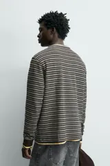 Camiseta de manga larga con cuello panadero y cierre frontal de botones, confeccionada en tejido de algodón elástico con diseño de rayas horizontales.
