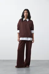 Buzo de manga larga color marrón chocolate, con silueta relajada, hombros caídos y diseño minimalista. Confeccionado en tejido suave con caída fluida.