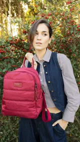 Mochila capitoneada color verde militar, confeccionada en nylon. Tiene apertura superior con cierre y tiradores metálicos, bolsillos internos, bolsillo frontal con cierre metálico, correa corta de mano y correas de galón regulables para colgar en la espalda.