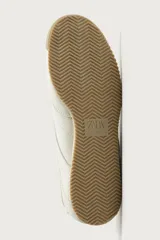 Zapatilla de estilo retro con cordones, confeccionada en una combinación de piezas de cuero sintético en color blanco, con suela dentada de goma en tono caramelo.