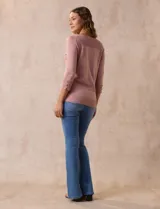 Buzo color rosa de tejido combinado con detalle de botones en las mangas y cuello redondo.