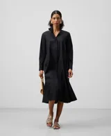 Vestido camisero midi negro de algodón, lyocell y poliéster, con cuello tira, manga larga y botonadura frontal oculta.