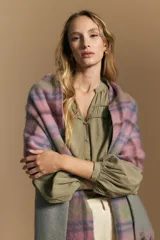 Camisa de manga larga color blanco, con cuello mao y escote en V. Presenta frunces en el canesú, cierre frontal con botones y mangas amplias con puños abotonados.