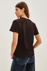 Remera de algodón color negro con estampa frontal circular que incluye la frase 'Rockstar Dreams' y estrellas decorativas.