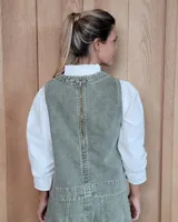 Chaleco de corte recto y largo a la cintura, confeccionado en denim con estampado de rayas verticales en tonos azul y blanco. Presenta cuello redondo y costuras visibles que definen su estructura.