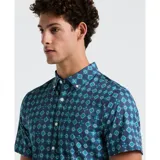Camisa de hombre de manga corta con estampado geométrico en tonos azules. Tiene cuello abotonado y corte clásico.