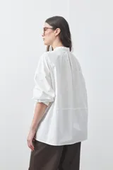 Camisa de manga larga en color celeste, con cuello mao y cierre frontal oculto. Presenta un diseño de silueta relajada con sisa caída y un bolsillo aplicado en el pecho.