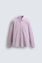 Camisa de corte regular fit confeccionada en tejido de algodón con textura. Presenta cuello solapa, cierre frontal de botones, manga larga con puños abotonados y un bolsillo plastrón en el pecho.