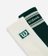 Kit de dos pares de medias deportivas de caña alta marca Wilson. Un par es de color blanco con logo negro y el otro es de color marrón con rayas horizontales celestes y blancas y logo bordado. Cuentan con tejido acanalado en la caña para un mejor ajuste.