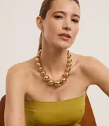 Collar dorado con esferas de tamaño gradual y cierre de gancho.