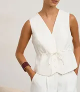 Pulsera rígida de metal con acabado en poliuretano color bordó y detalles dorados. Presenta una abertura para facilitar su colocación.