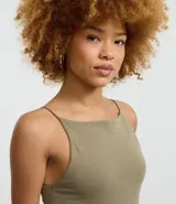 Vestido midi de corte ajustado, confeccionado en tejido de algodón con elastano. Presenta escote recto, breteles finos y una abertura en la parte trasera del ruedo.