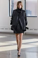 Cazadora negra de Zara Woman Collection, con cuello solapa y manga larga. Tiene bolsillos con cremallera en el delantero, interior de borreguillo combinado a tono y bajo con cinturón ajustable con hebilla metálica. El cierre es frontal con cremallera.