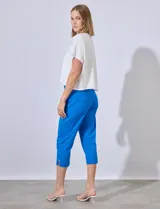 Pantalón capri de gabardina elastizada color celeste, con bolsillos simulados delanteros y bolsillos aplicados traseros. Tiene pretina ancha, corte recto y detalle calado en el ruedo.