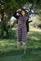 Chaqueta de corte entallado con cuerpo en tejido tartán de lana en tonos tierra y verde, y mangas largas en color marrón liso. Presenta cuello mao con volado frontal, cierre frontal y bolsillos con solapa.