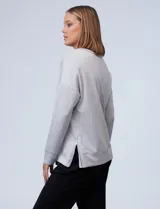 Buzo de cuello redondo y manga larga, confeccionado en tejido modal gris melange. Presenta un corte recto con costura horizontal en el pecho y puños ajustados.