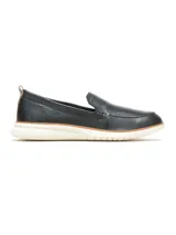Mocasín tipo slip-on de cuero negro con acabado ligeramente brillante, suela de goma blanca con detalle de línea color tostado y tirador en el talón.