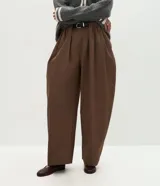 Pantalón barrel de algodón color marrón, con cintura alta, pliegues delanteros, perneras amplias y bajo afinado, diseñado con presillas y un cinturón incluido.