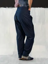 Pantalón babucha de denim azul, con corte a la cintura baja y diseño tipo origami. Presenta pliegues y costuras que favorecen la silueta. Creado y producido en Uruguay.