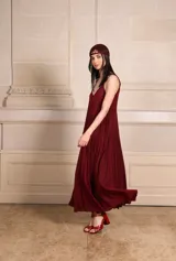 Vestido largo plisado color borgoña con lurex, escote en V y breteles finos.