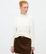 Suéter de punto texturizado con cuello alto, diseño oversized y mangas largas. Presenta una caída amplia y una superficie encorpada, ideal para un estilo moderno y acogedor.