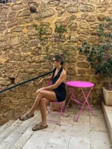 Vestido corto negro con escote halter y cierre frontal con cremallera dorada.