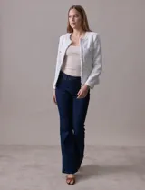 Chaqueta Nanette de tejido tweed color blanco, con escote mao, abertura central y bolsillos delanteros. Presenta apliques de botones perlados en los puños y terminación desflecada.