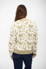 Saco tipo cardigan de tejido de punto con diseño floral en contraste, cuello en V y cierre frontal con botones. Presenta puños y ruedo acanalados.