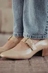 Zapato de charol negro con hebilla metálica ajustable y taco cuadrado.