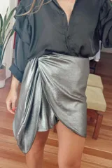 Minifalda plateada con diseño cruzado y drapeado frontal.