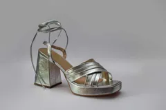 Sandalias color beige con plataforma y tacón cuadrado. Presentan tiras cruzadas en el empeine y tiras largas para atar alrededor del tobillo.