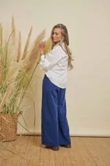 Camisa blanca de algodón con cuello clásico, botones frontales y mangas largas con puños abotonados.