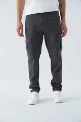 Pantalón cargo gris oscuro, corte slim, con cierre de botón y cremallera, trabillas para cinturón y bolsillos cargo con botón.