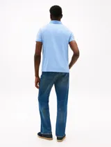 Chomba celeste de piqué de algodón con cuello clásico, tapeta de dos botones y logo de Tommy Hilfiger bordado en la manga.