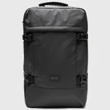 Mochila de viaje color negro, diseñada para cabina, con correas de ajuste laterales, bolsillo frontal superior y compartimento lateral para botella. Presenta un diseño minimalista con etiqueta de marca en el frente.