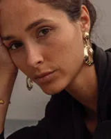 Par de aros colgantes de bronce y alpaca color plateado, con forma orgánica irregular y textura martillada. Cierre con perno y mariposa de plata 925.