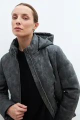 Campera gris oscuro de eco-cuero capitoneada con capucha y cierre frontal.