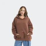 Buzo tipo hoodie color marrón, de corte oversize, con capucha, bolsillo frontal tipo canguro y estampado minimalista en el centro del bolsillo.